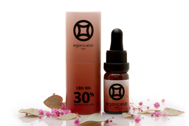 aceite cbd 30% con. su. envase al lado, sobre. fondo. blanco decorado con lores secas