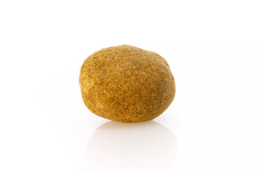 Bola de hachís de maximum cannabinoid power, anranjada sobre superficie blanca