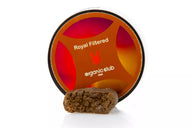 Pieza de hash color marrón cremoso con su correspondiente tarro sobre fondo blanco