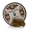 Envase de Super Polen CBD9 Organic Club con pieza de polen CBD oscuro sobre fondo blanco